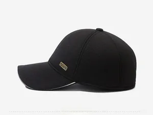 Detail of black corduroy baseball cap with metal plaque and contrast trim