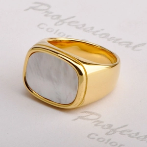 Detailed close-up of a gold square signet ring featuring a polished white shell inlay