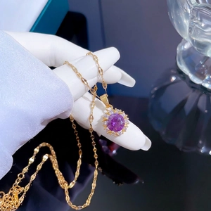 Titanium steel gold necklace with purple gemstone and pavé diamonds held by model