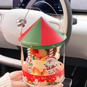 Close-up of Christmas carousel cupcake box with LED lights and strawberry cake detail