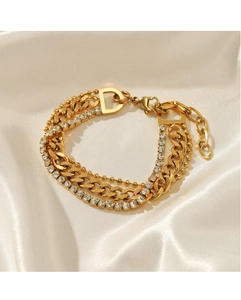 Close-up of triple-layered gold chain bracelet with rhinestones and D-letter charm