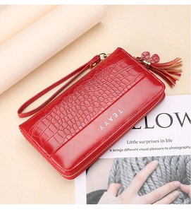 Close-up of a red crocodile pattern long wallet with zipper and tassel detail