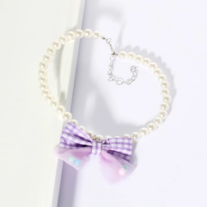 Detail of pet pearl necklace with a purple plaid bow and adjustable silver chain