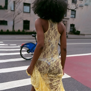 Vue street style d'une robe longue sans manches en dentelle jaune à motifs floraux