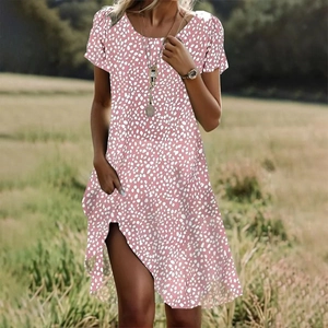 Robe d'été rose à fleurs avec col rond et ourlet asymétrique portée par un mannequin