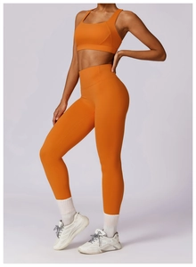 Close-up of vibrant orange high-waist yoga leggings and matching athletic sports bra