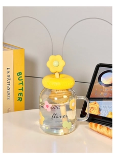 Detailed macro view of a glass mug with yellow flower lid and wooden honey stir spoon