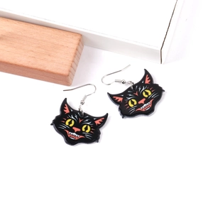 Close-up of black acrylic Halloween earrings with printed cartoon cat face design