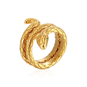 Gold snake ring with textured scales and green gemstone eyes on a white background