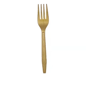 Detail view of a single gold plastic fork with diamond pattern handle on white background