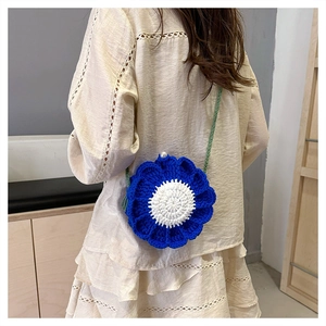 Detailed view of handmade flower knit crossbody bag with pearl button closure detail