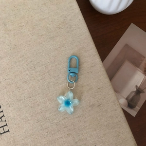 Detail view of light blue translucent flower keychain with silver metal ring and clip
