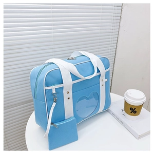Detail of blue JK uniform heart ita bag with transparent window on a white table