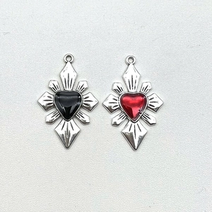 Detail of gothic silver cross pendants with heart-shaped red and black gems