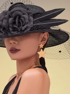 Detail of gold star earrings and matching necklace worn by model on beige background