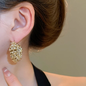 Close-up of elegant gold multi-layer wrap earrings with crystal pavé on female model