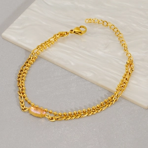 Detail of gold double-layer chain bracelet with a pink marquise zircon and extension chain