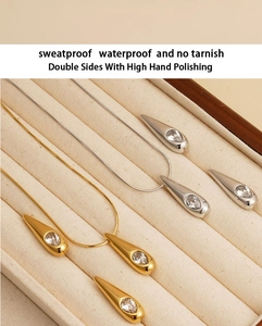 Detail von Gold und Silber Wassertropfen Schmucksets auf einem beigen Tablett