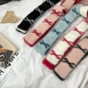 Multiple knit scarves with bow patterns in black, pink, blue, and white colors