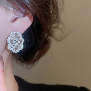 Détail de boucles d'oreilles ovales évidées en argent avec zircons sur le modèle
