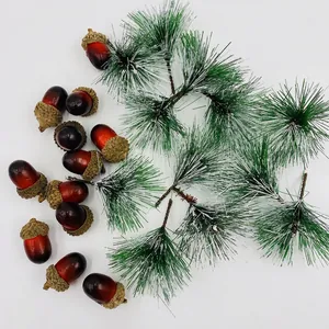 Christmas decoration set with snow-dusted pine needles and glossy red-brown acorns