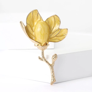 Detailed close-up of yellow enamel lily flower brooch with gold plating and fine textures