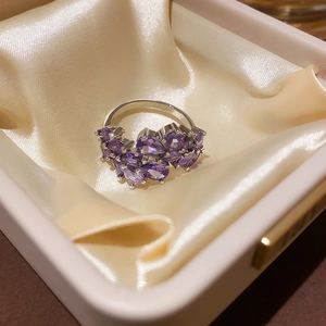 Macro detail of silver ring featuring purple pear-cut cubic zirconia in a cluster setting