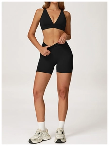 Détail de la brassière de sport noire à col en V et du short de yoga taille haute assorti