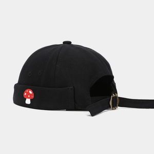 Detail of mushroom embroidery and adjustable brass buckle on black brimless hat