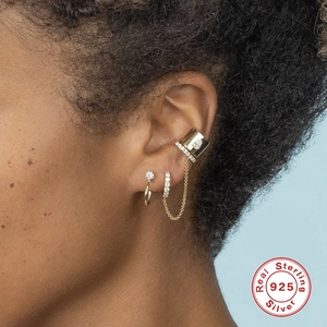 Detail of 925 sterling silver gold cuff earrings with fine chains and sparkling crystals