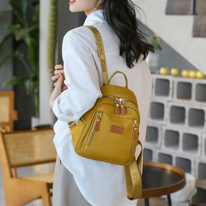 Fashionable bright yellow nylon mini backpack for women shown on model for casual commuting