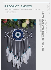 Detailed view of handmade fish-shaped dreamcatcher with blue evil eye and white feathers