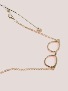 Close-up of golden glasses chain with eyeglass charm, lobster clasp and silicone loops