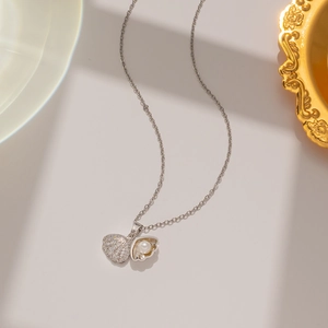 Macro detail of silver shell pendant with sparkling zircon and white pearl on a fine chain
