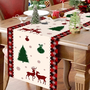Christmas table runner with red reindeer and tree patterns on a rustic wooden dining table