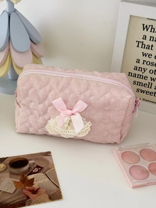 Detailed view of pink quilted heart pouch with satin bow and delicate lace trim