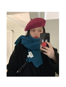Close-up of thick knitted peacock blue scarf paired with a plum wool beret for winter