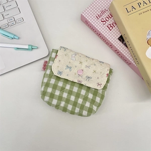 Detail of a quilted plaid storage pouch with a cute rabbit print and snap button closure