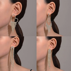 Macro view of silver tassel earrings with crystal heart and geometric fringe details