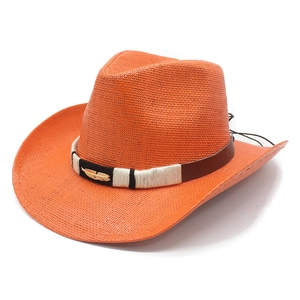 Detail of western straw cowboy hat featuring brown leather band and golden feather ornament