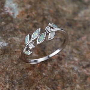 Macro view of olive branch ring with silver leaf pattern and opal stone inlay