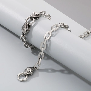 Macro detail of silver stainless steel chain with a unique snake head pendant design