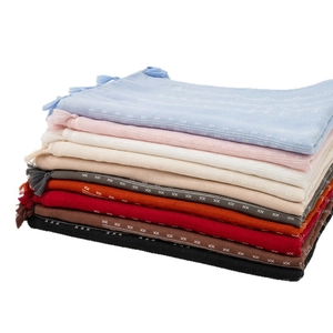Stack of multi-color cotton linen scarves with fringes for travel and sun protection