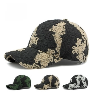 Detail of floral relief patterns on curved brim baseball caps in multiple colors