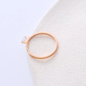 Elegant rose gold titanium ring with a central diamond and side accents on a white base