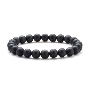 Detail view of natural matte black lava stone beads on a crystal stretch bracelet