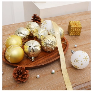 Détail de boules de Noël texturées or et blanc avec flocons sur un plateau en bois