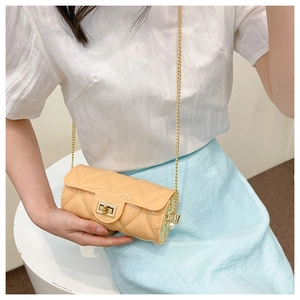 Detail of apricot quilted jelly bag featuring a gold clasp and elegant pearl accents