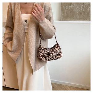 Détail du sac sous le bras à motif léopard avec chaîne et tenue en cardigan tricoté