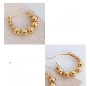 Detail showing the 18K gold-plated surgical titanium steel spherical bead earrings